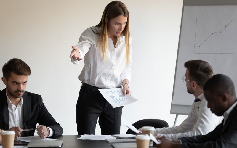 Female leader pointing, addressing team meeting